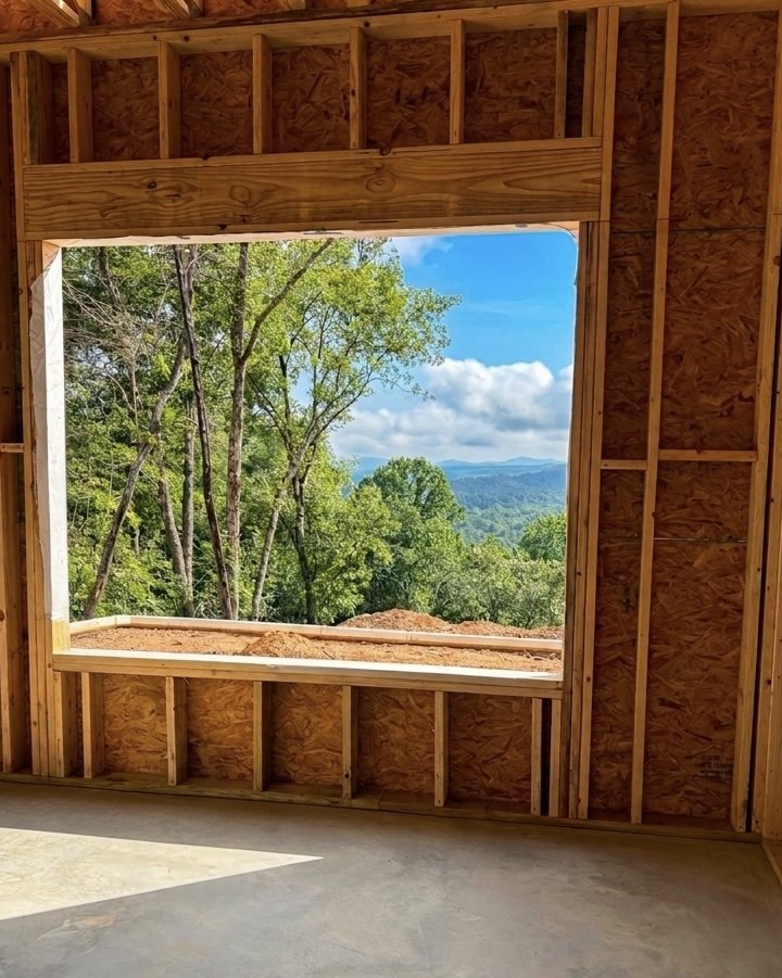 A framed window opening at the Ritzy Ridge build site, perfectly framing the Blue Ridge mountain view beyond